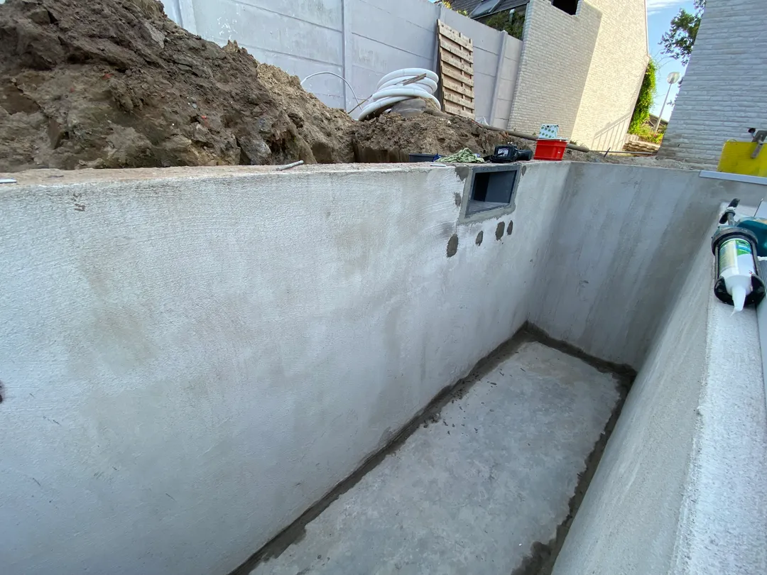 Zwembadbouw in beton met skimmer en gladde wandafwerking tijdens de constructie