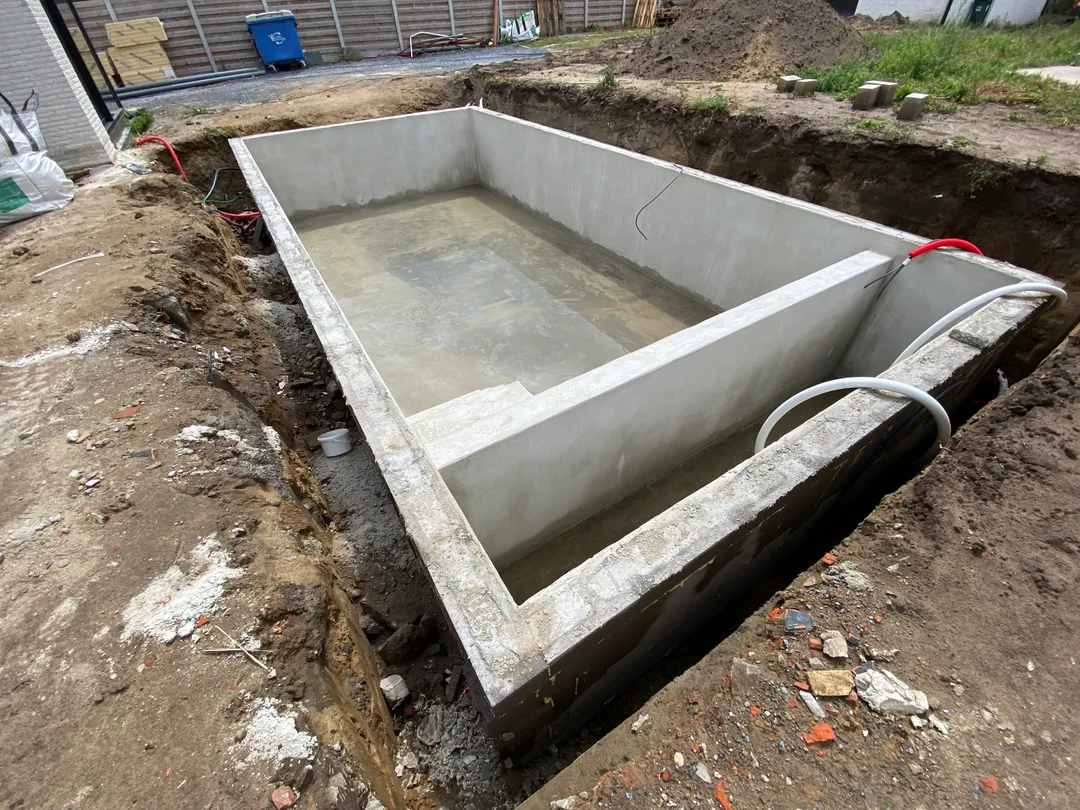 Betonnen zwembadkuip in de ruwbouwfase, gereed voor het plaatsen van een zwembadliner op maat